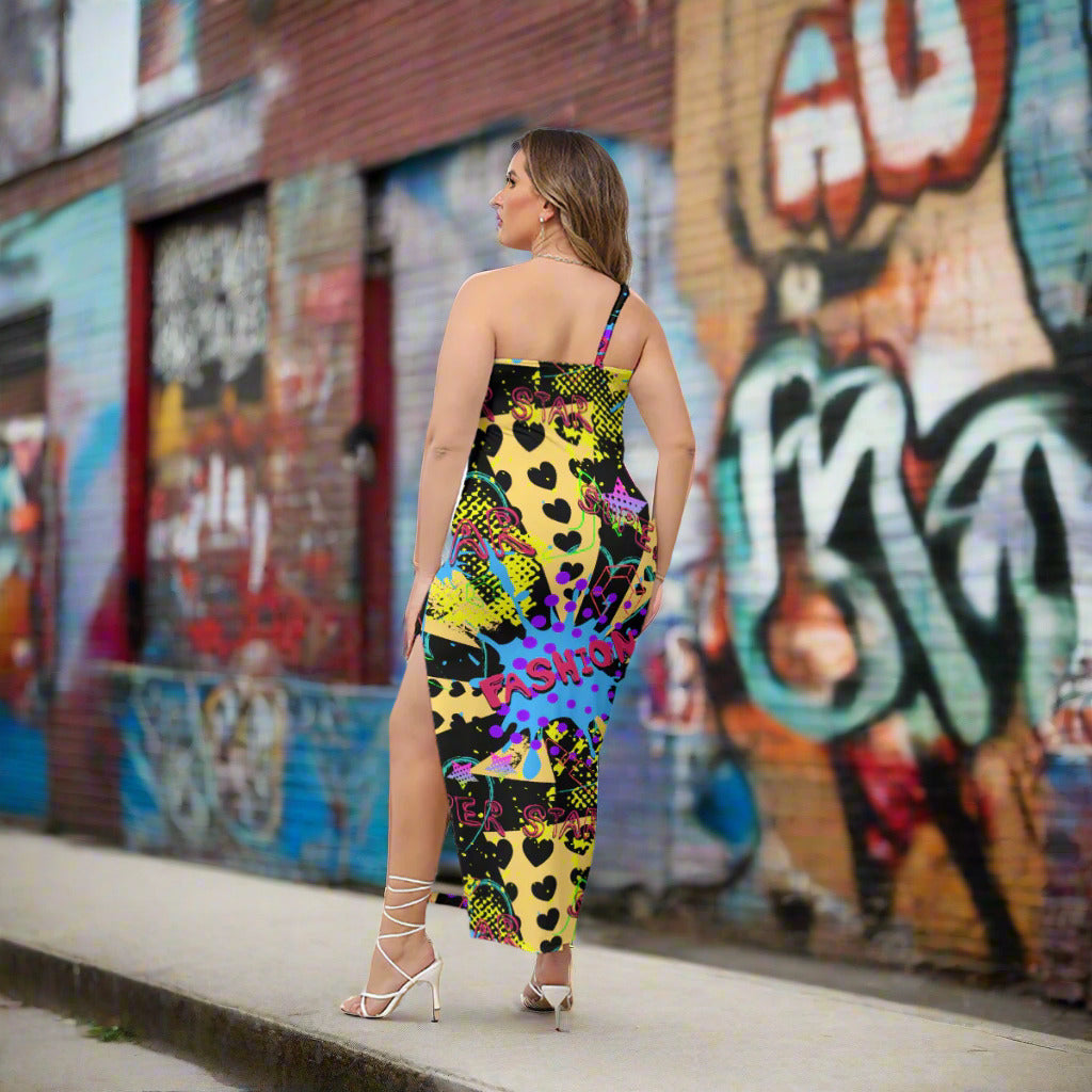 Woman wearing a colorful dress with heart patterns in a graffiti outdoor setting.